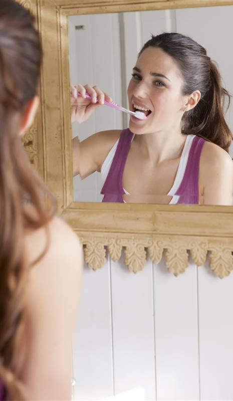mujer lavándose los dientes