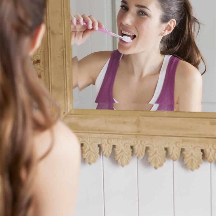 mujer lavándose los dientes