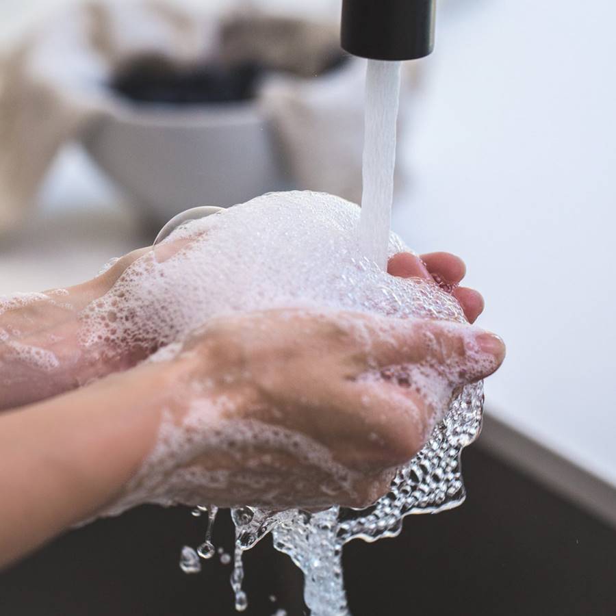 Mujer lavándose las manos con jabón