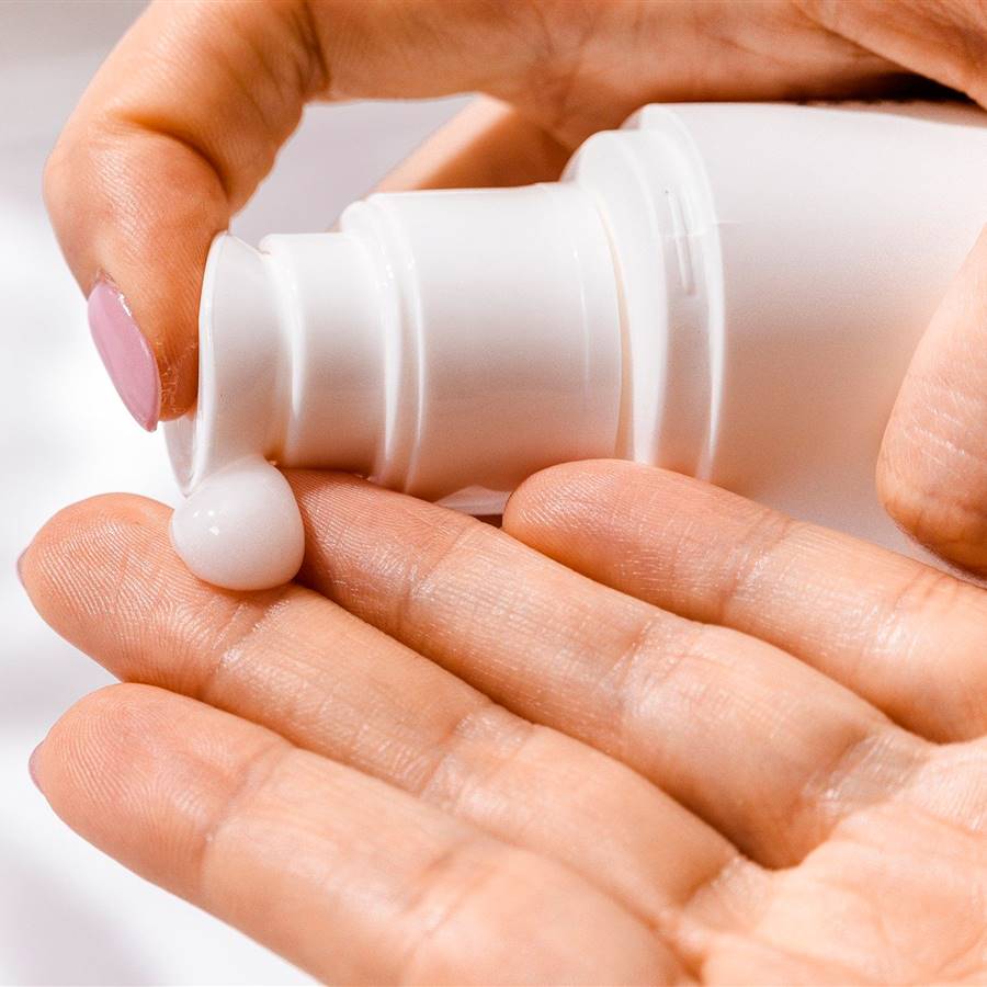 Mujer poniéndose crema de manos