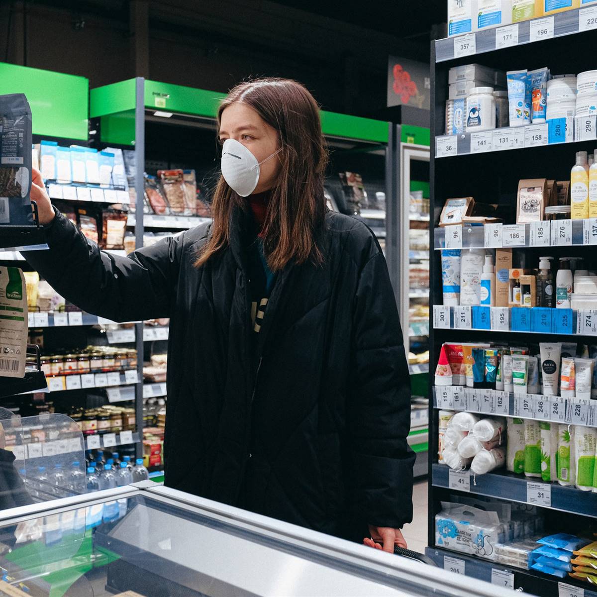 Mujer comprando en el supermercado con mascarilla