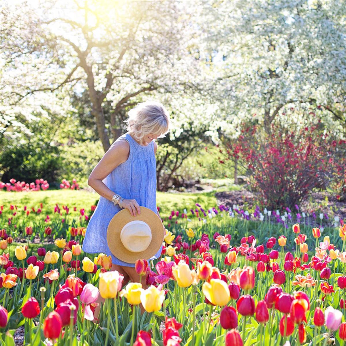 Mujer caminando por un parque floreado