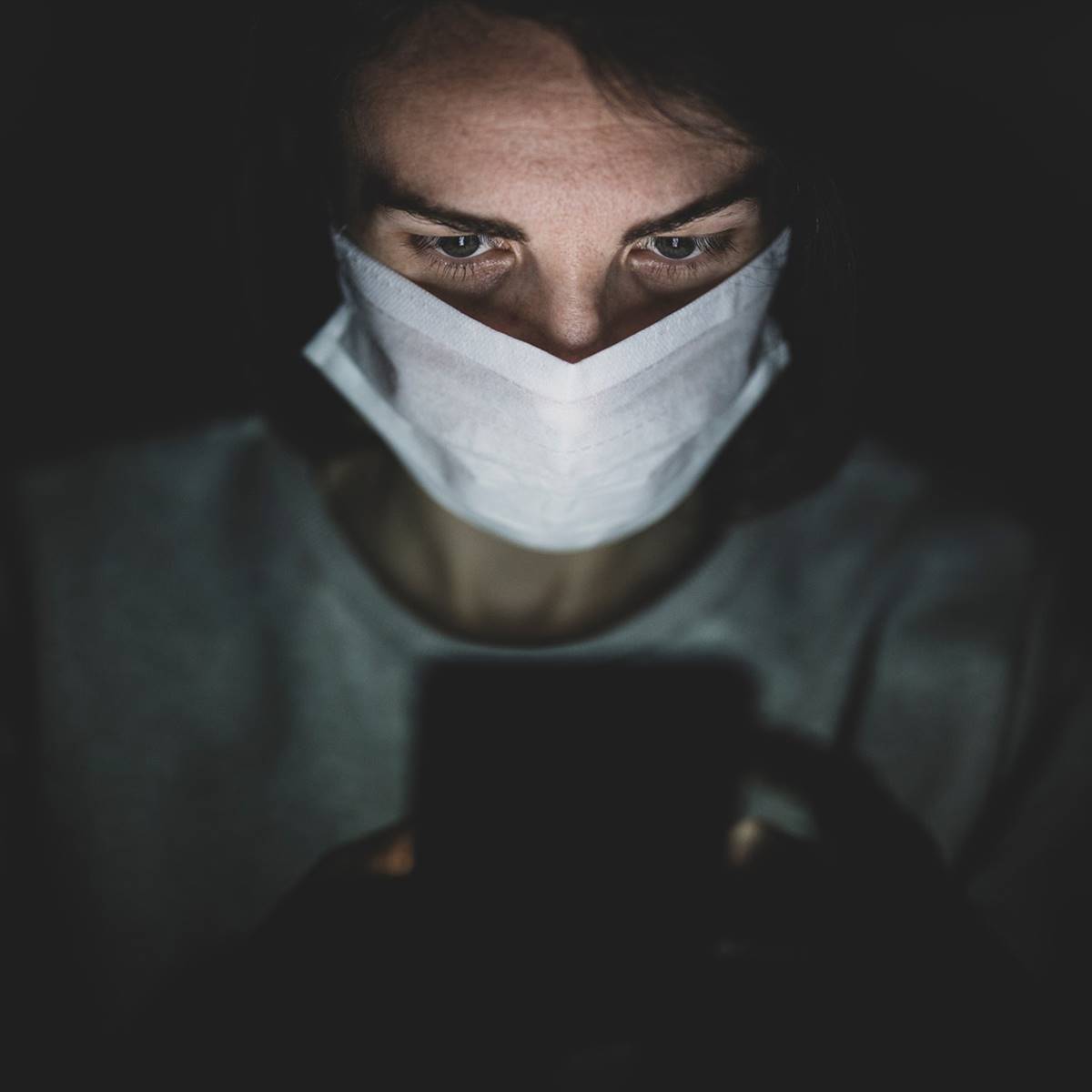 Mujer con mascarilla mirando el movil