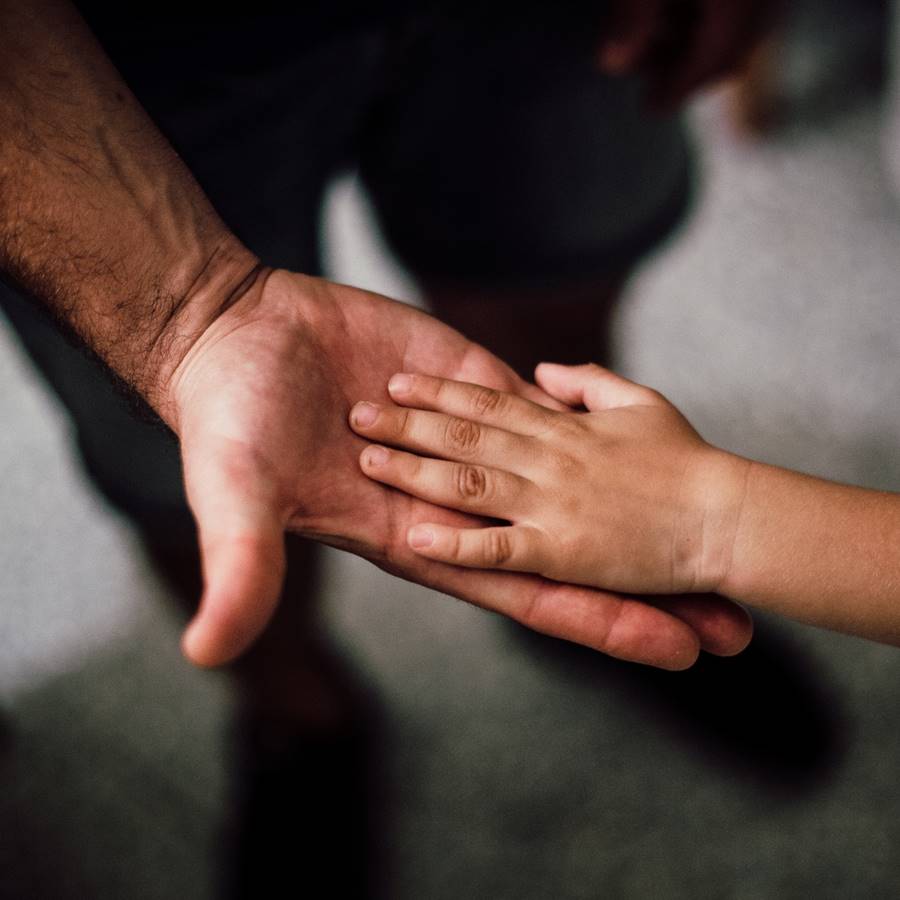 Un padre ofreciendo la mano a su hijo