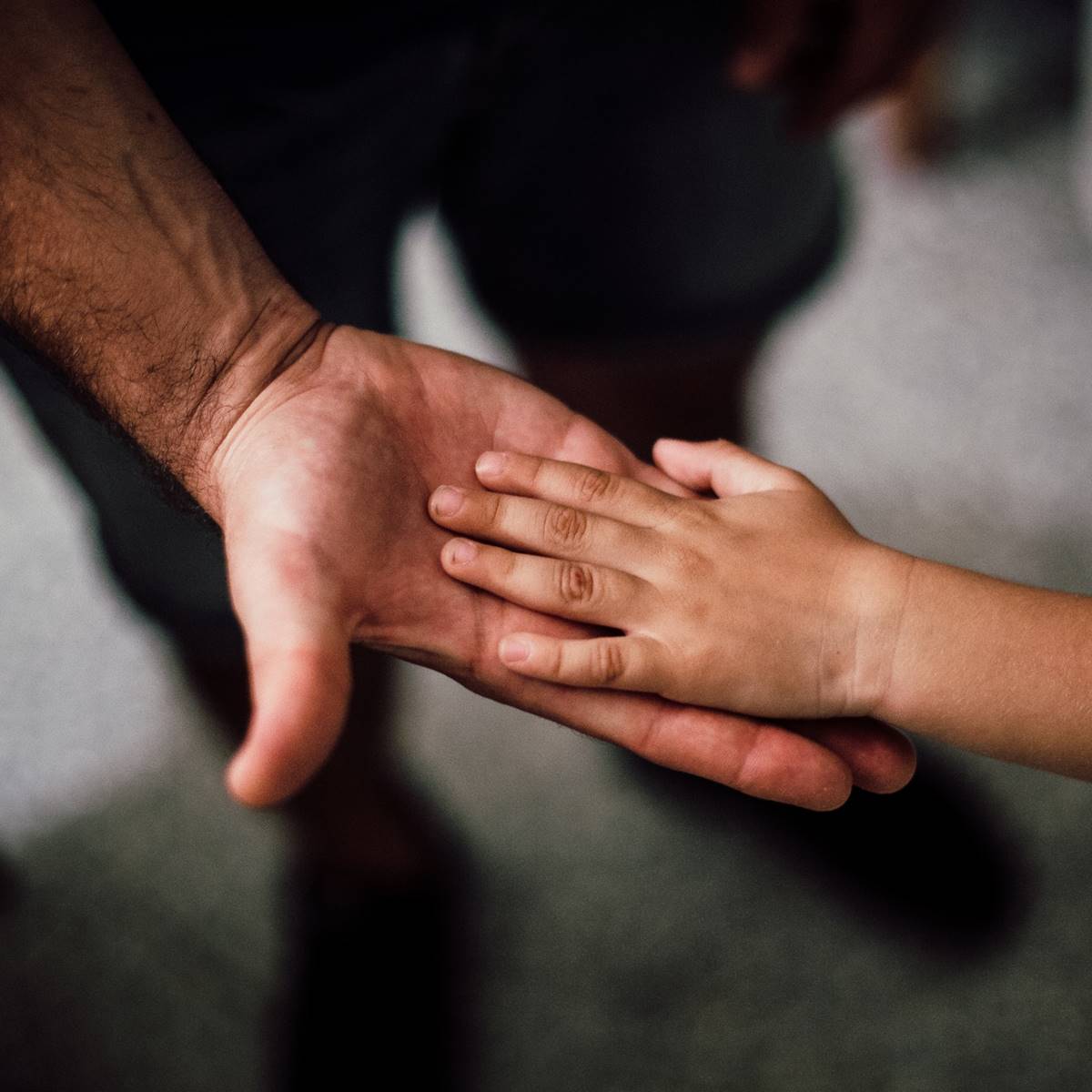 Un padre ofreciendo la mano a su hijo
