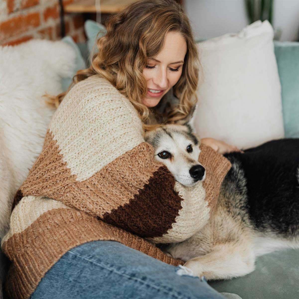 Mujer con perro en el sofá en invierno