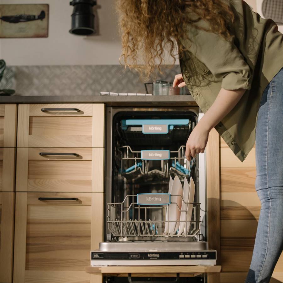 Mujer colocando platos en el lavavajillas