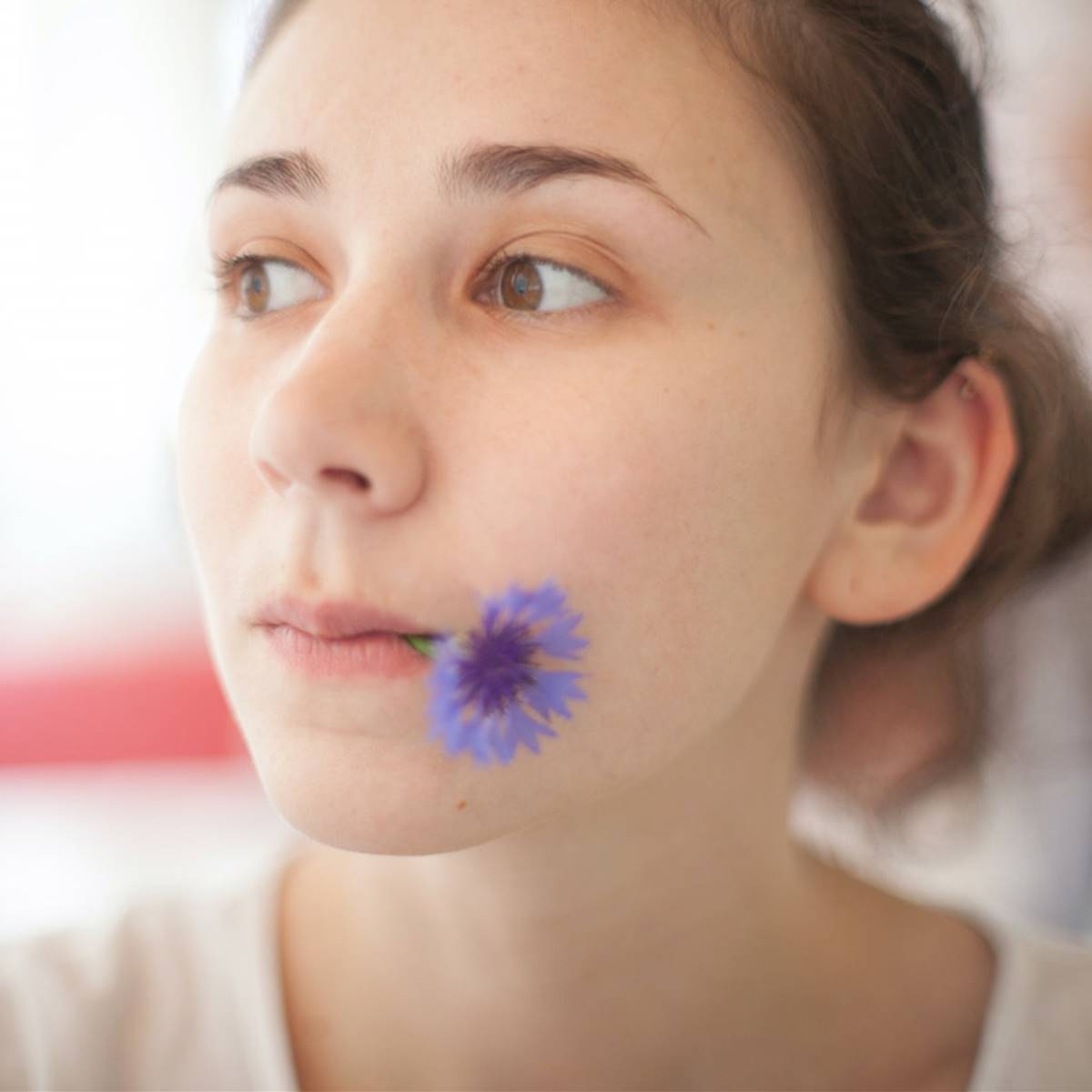 Chica con flor azul en la boca