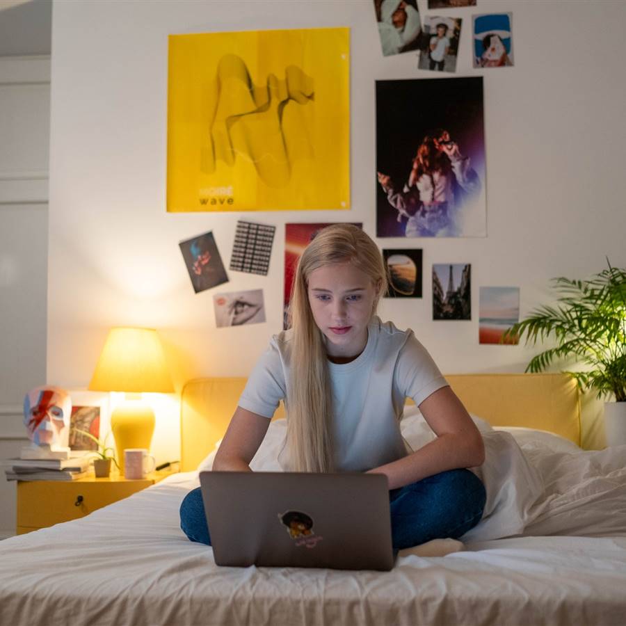 Adolescente en la cama con su portátil