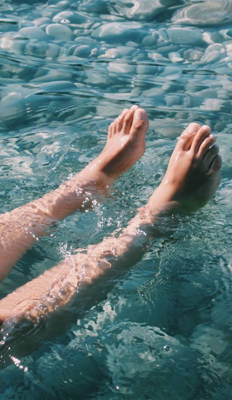 Piernas y pies de mujer en el agua