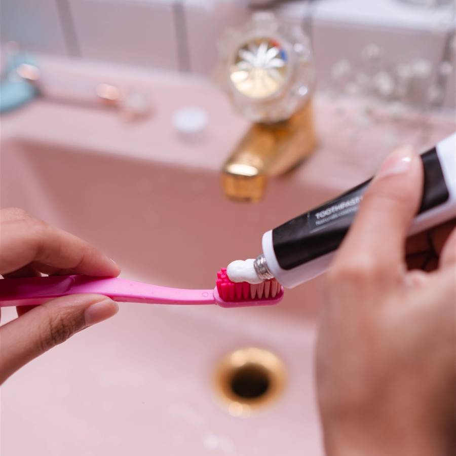 Mujer poniendo pasta de dientes en el cepillo