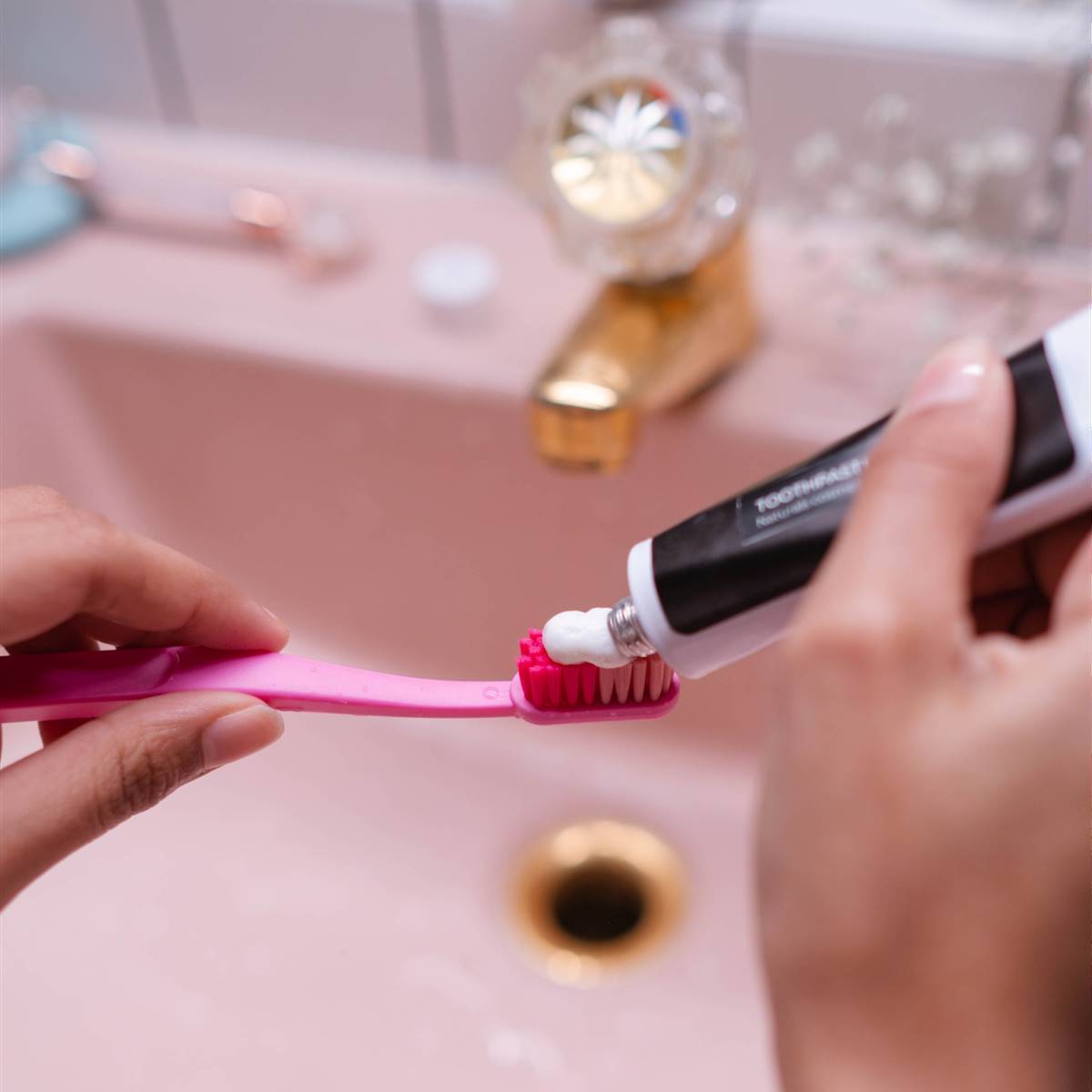 Mujer poniendo pasta de dientes en el cepillo
