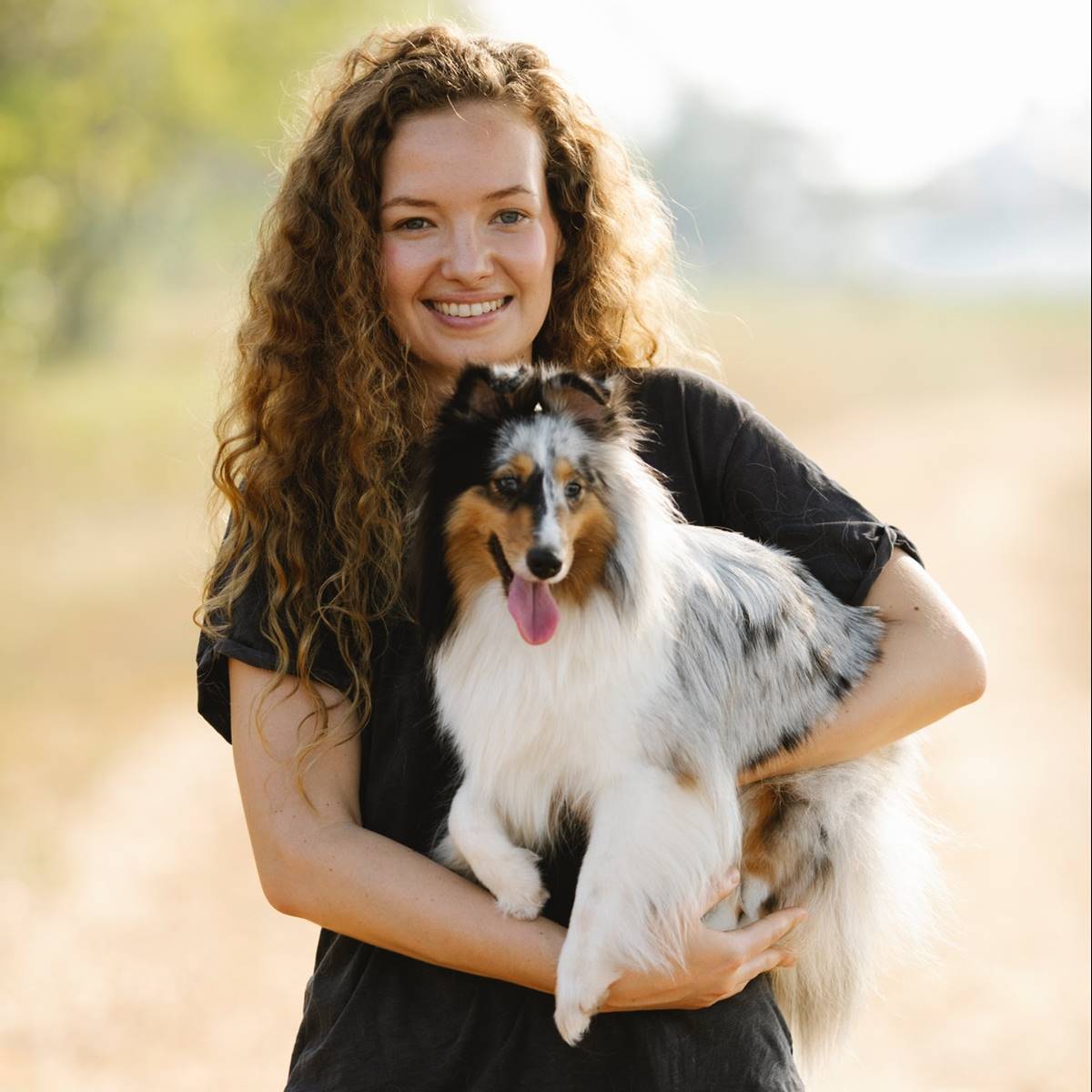 Mujer con un border collie en brazos