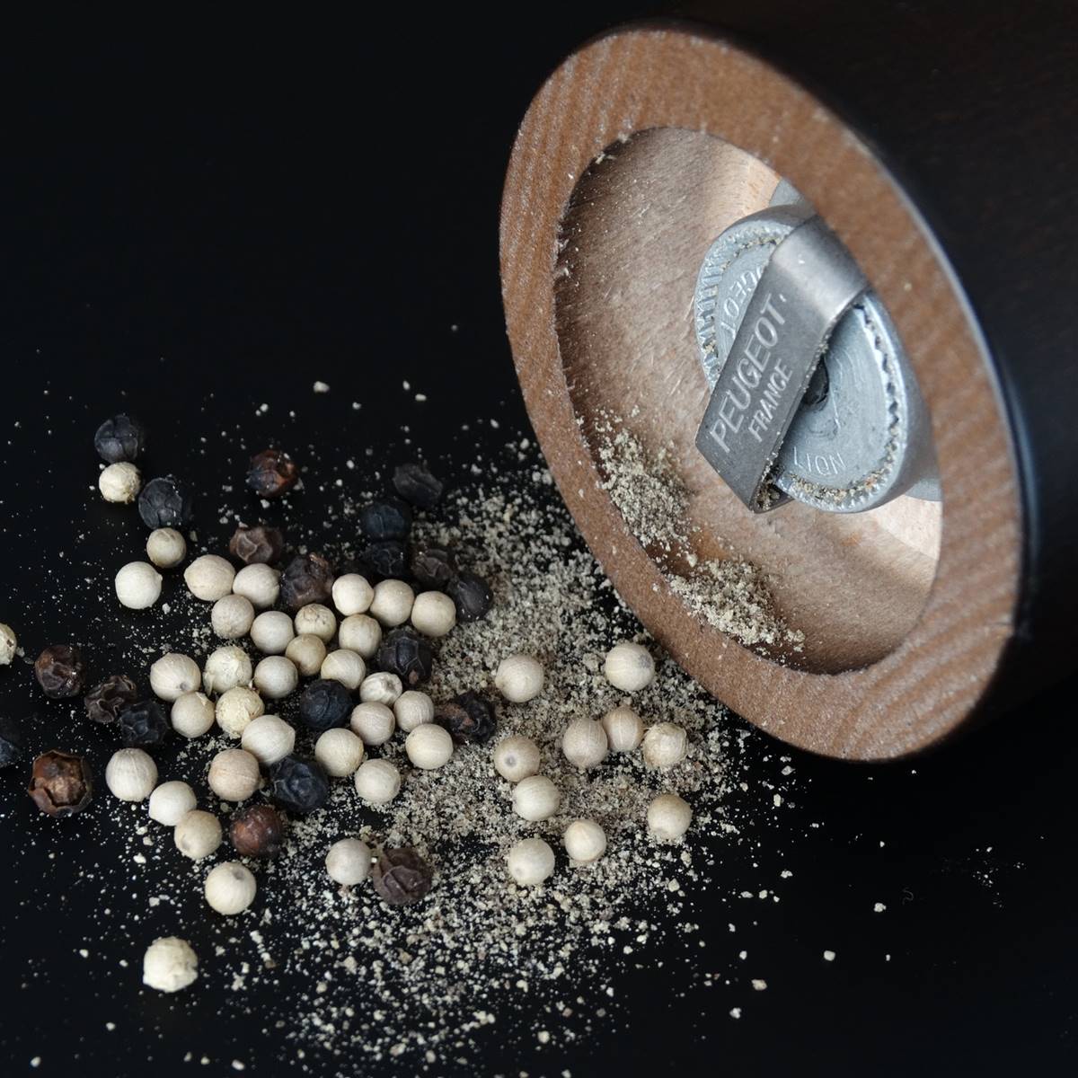 Molinillo de pimienta y granos de pimienta blanca