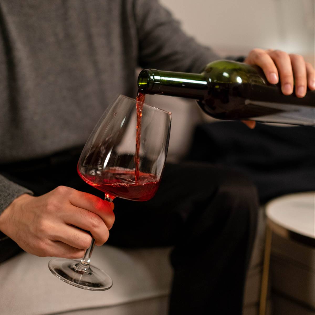 Hombre sirviéndose una copa de vino tinto