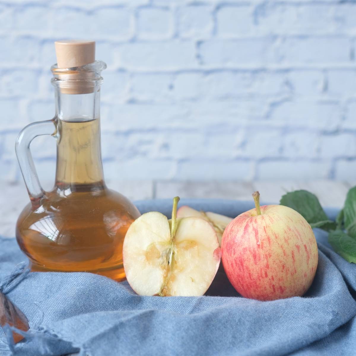 Jarra con vinagre de manzana y manzanas cortadas al lado