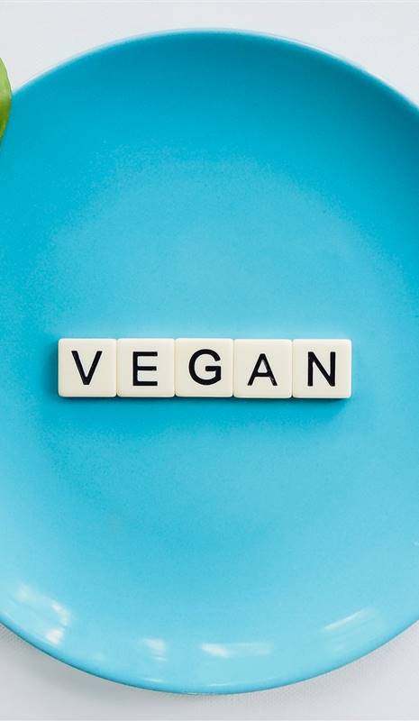 Plato azul con la palabra vegan escrita en piezas de scrabble