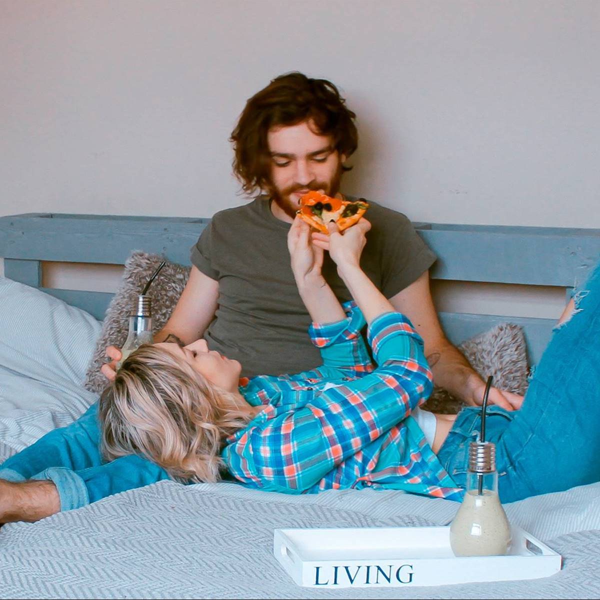 pareja en la cama comiendo