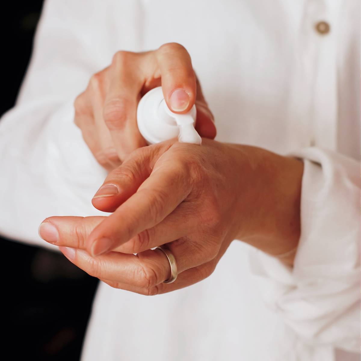 Mujer poniéndose crema de manos