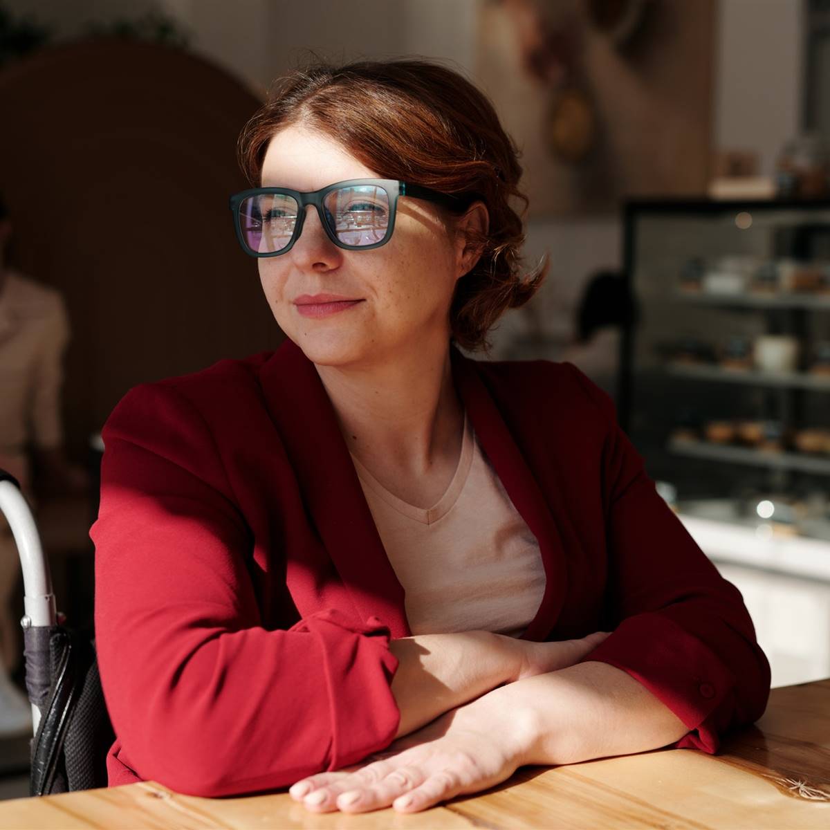 Mujer con gafas sentada mirando por la ventana