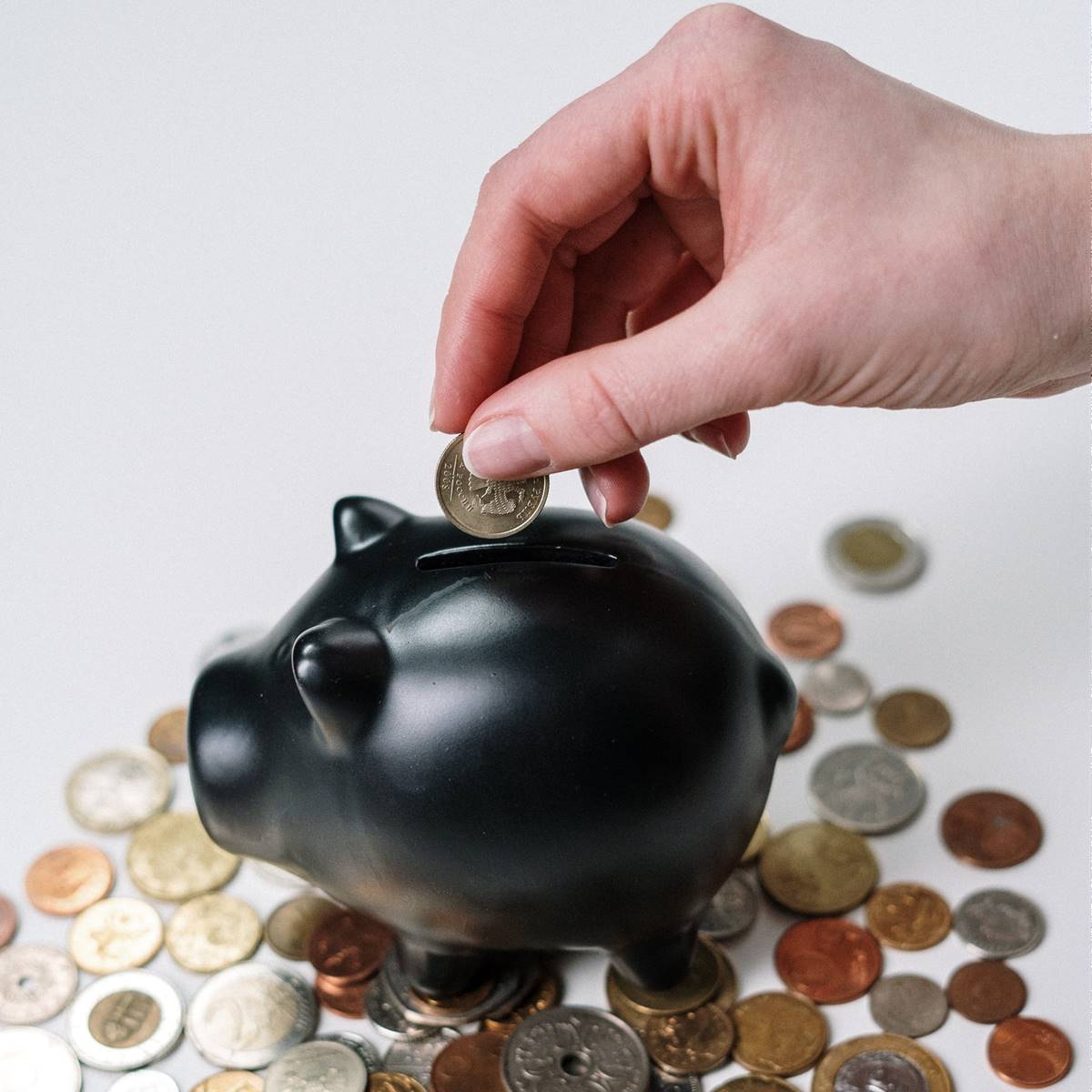 Mujer metiendo dinero en una hucha