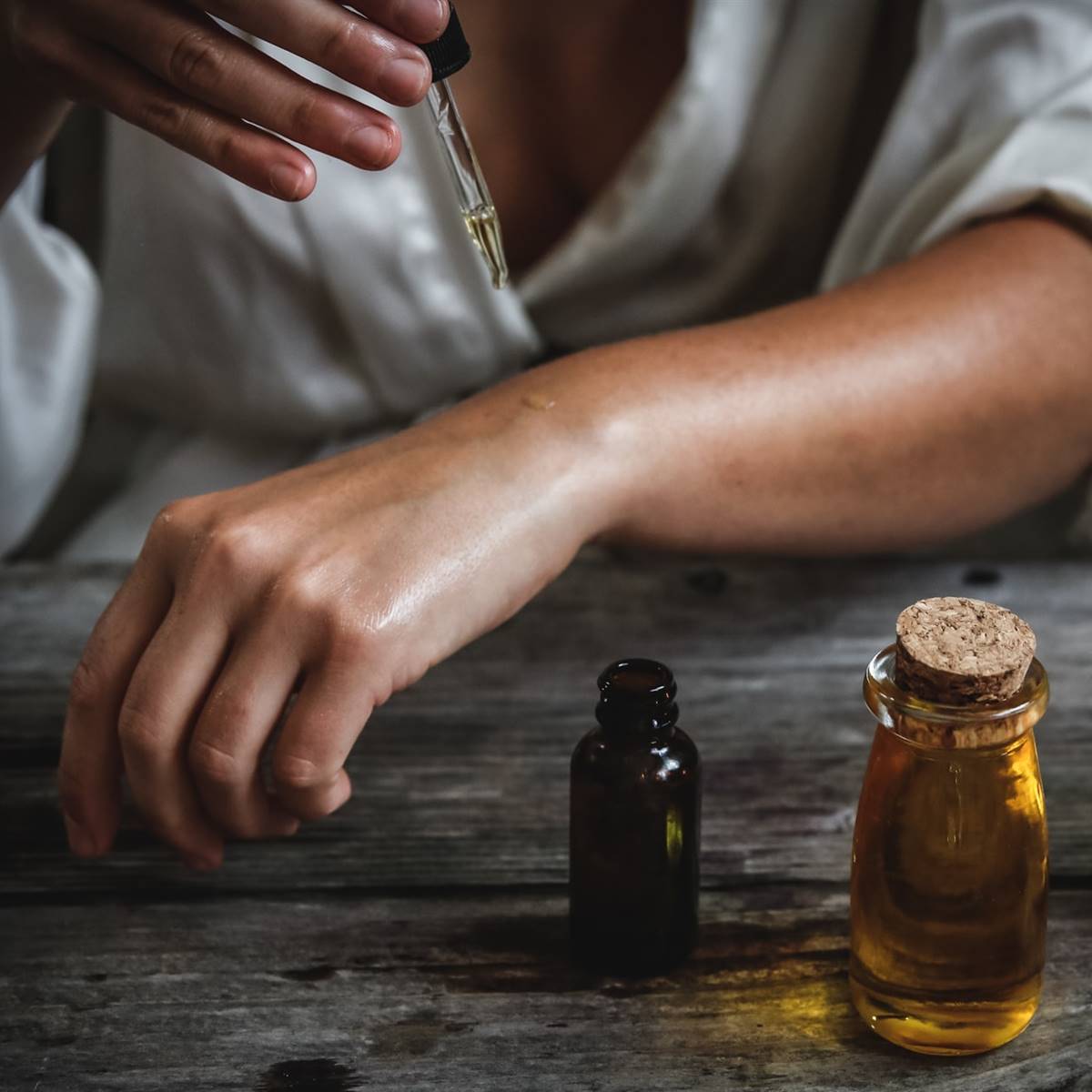 Mujer echándose aceite en la mano
