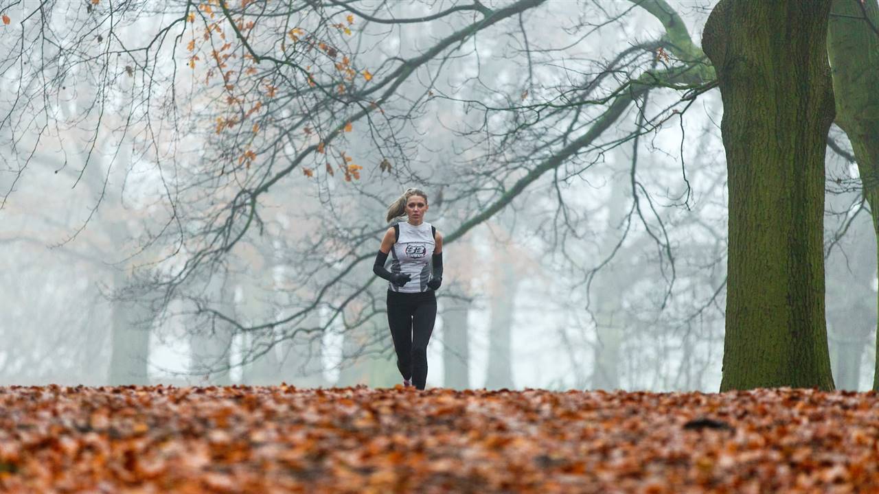 Mujer corriendo en exterior en otoño