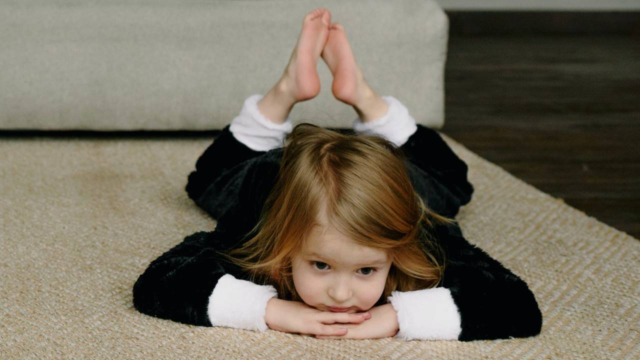Niña tumbada en la alfombra