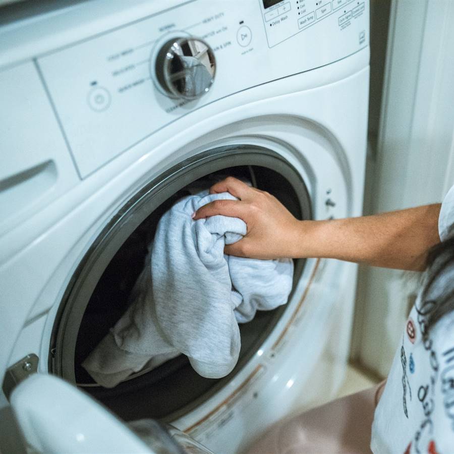 Mujer metiendo ropa en la secadora
