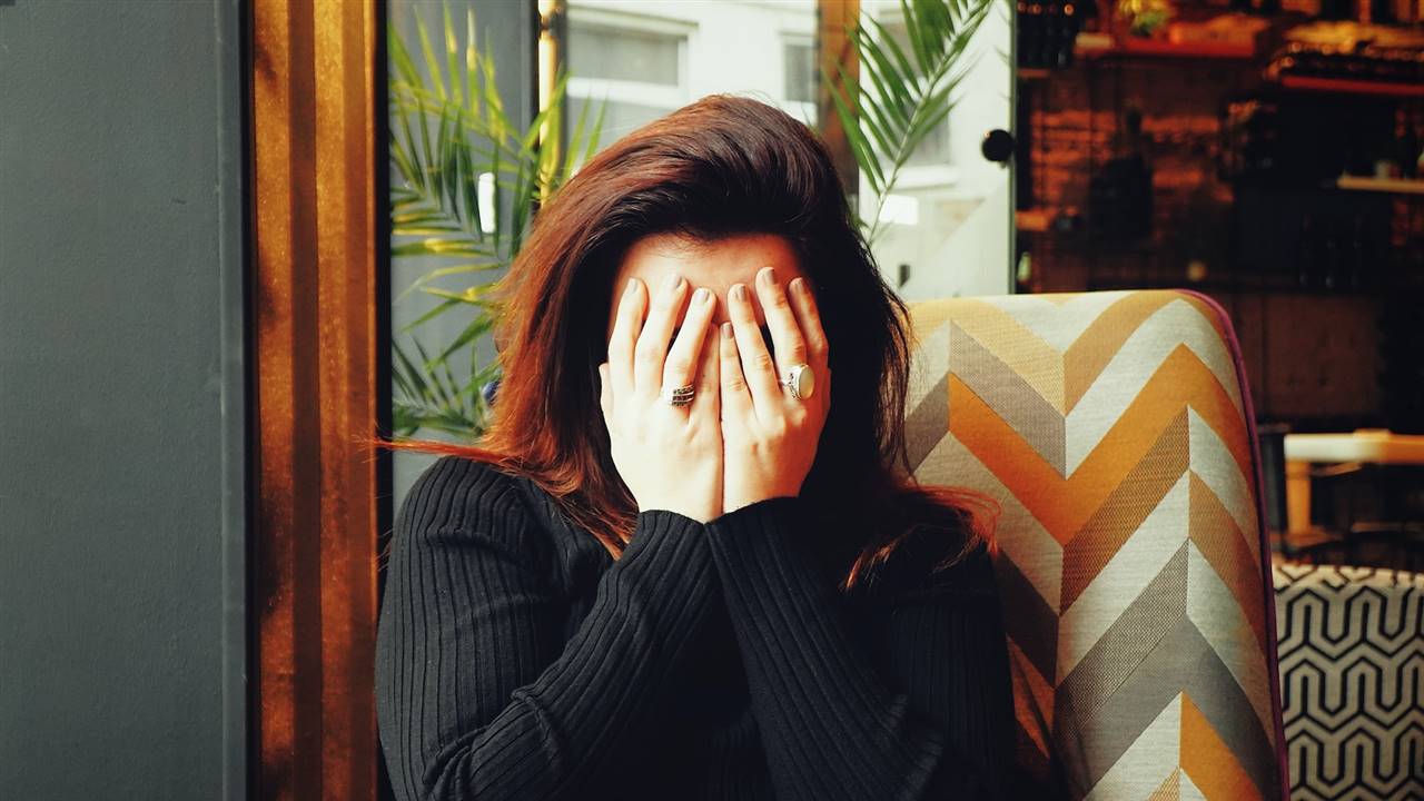 Mujer sentada en un sillón con los ojos tapados