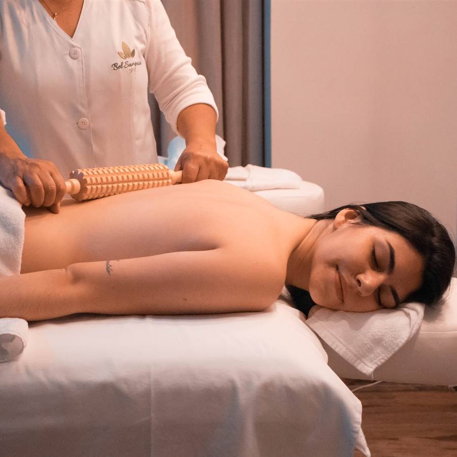 Mujer a la que están haciendo un masaje con rodillo de madera