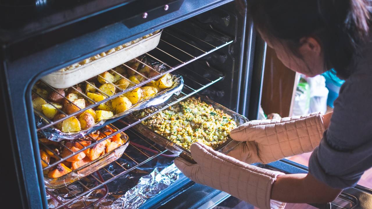 Mujer metiendo comida en el horno