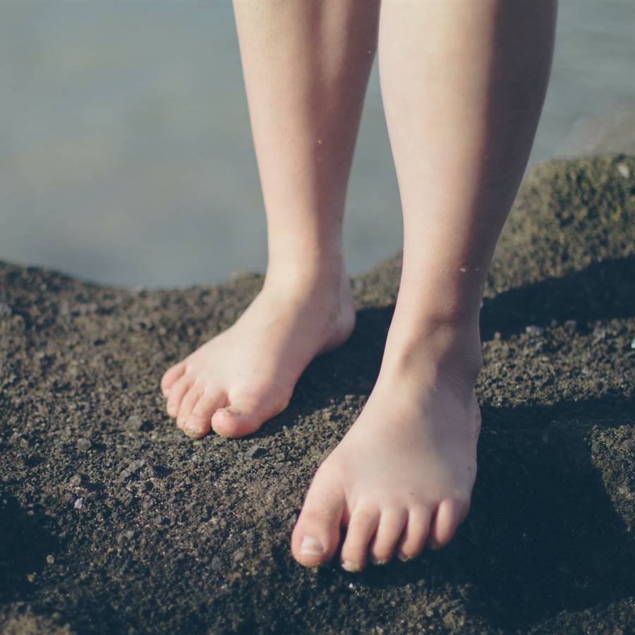 Pies de chica descalza sobre rocas