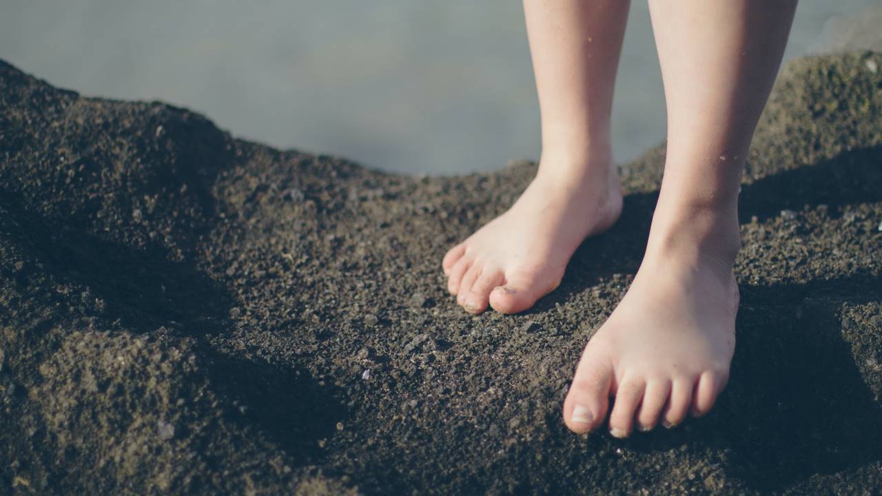 Pies de chica descalza sobre rocas