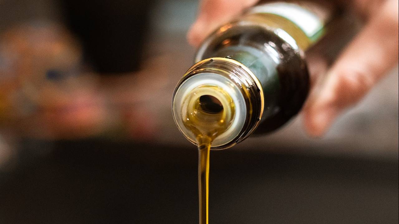 Mano vertiendo aceite de una botella