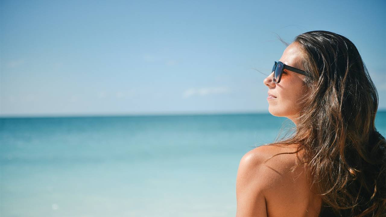 Mujer en la playa con gafas de sol