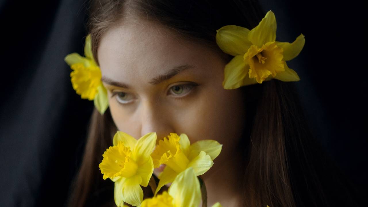 Chica con un ramo de narcisos y narcisos en el cabello