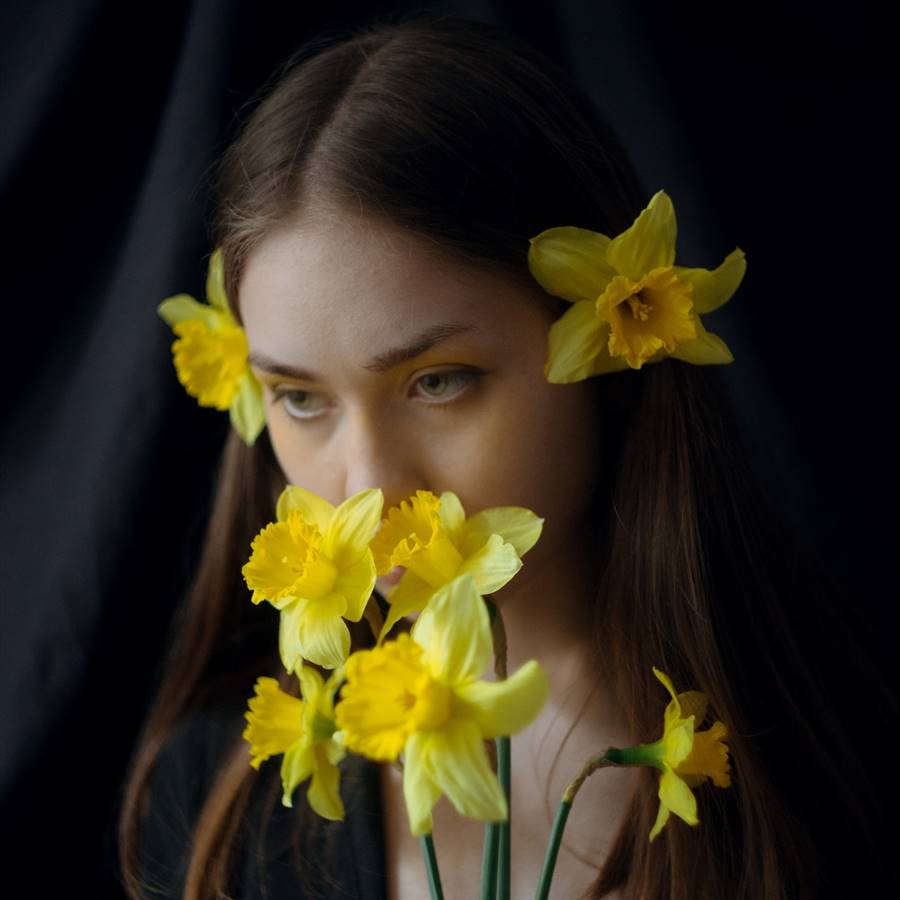 Chica con un ramo de narcisos y narcisos en el cabello