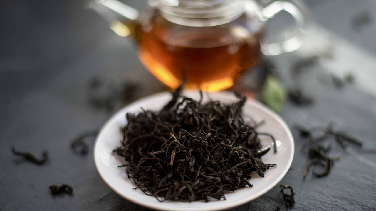 Té negro con tetera al fondo