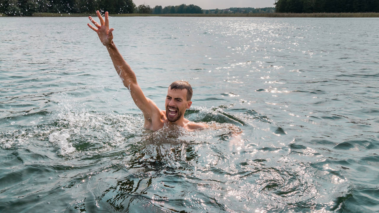 Hombre pidiendo ayuda en el agua