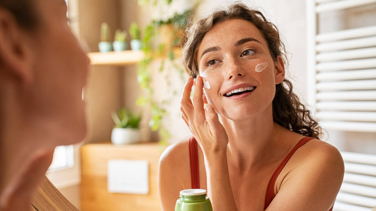Mujer poniéndose crema en el rostro