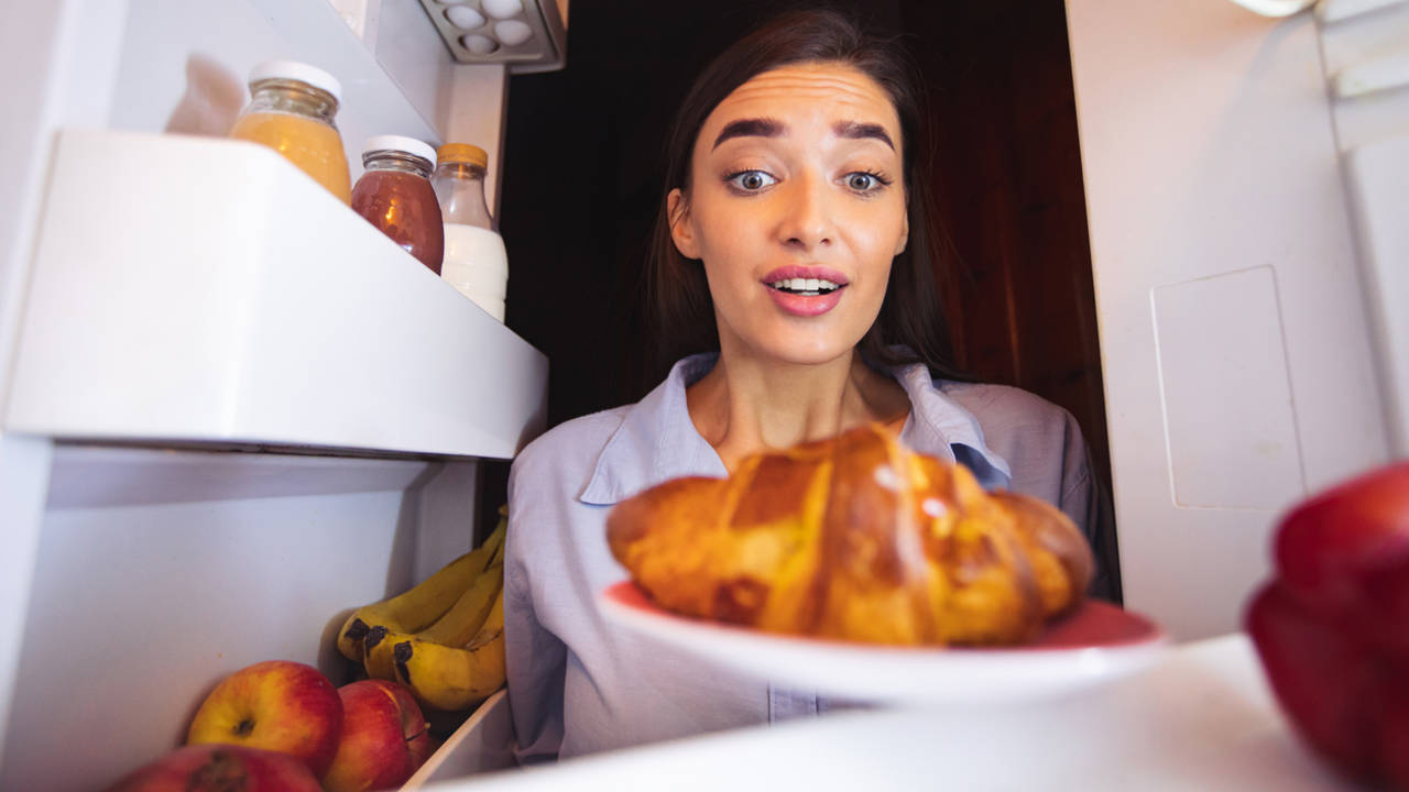 Chica cogiendo comida de la nevera