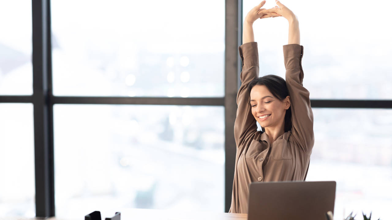 Mujer estirándose en la oficina